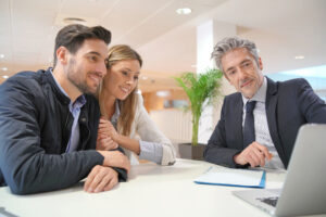 Real estate agent showing information to a couple on behalf of Dapper Sites, a website builder for real estate agencies